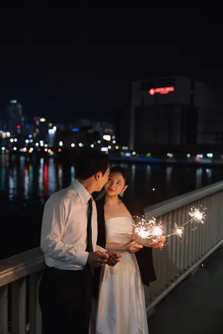 야경을 배경으로 스파클러를 함께 든 신랑과 신부
