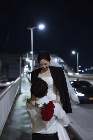 밤거리에서 붉은 장미를 들고 신부를 바라보는 신랑