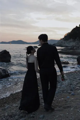 해변에서 손을 잡고 바다를 바라보는 신랑과 신부의 뒷모습