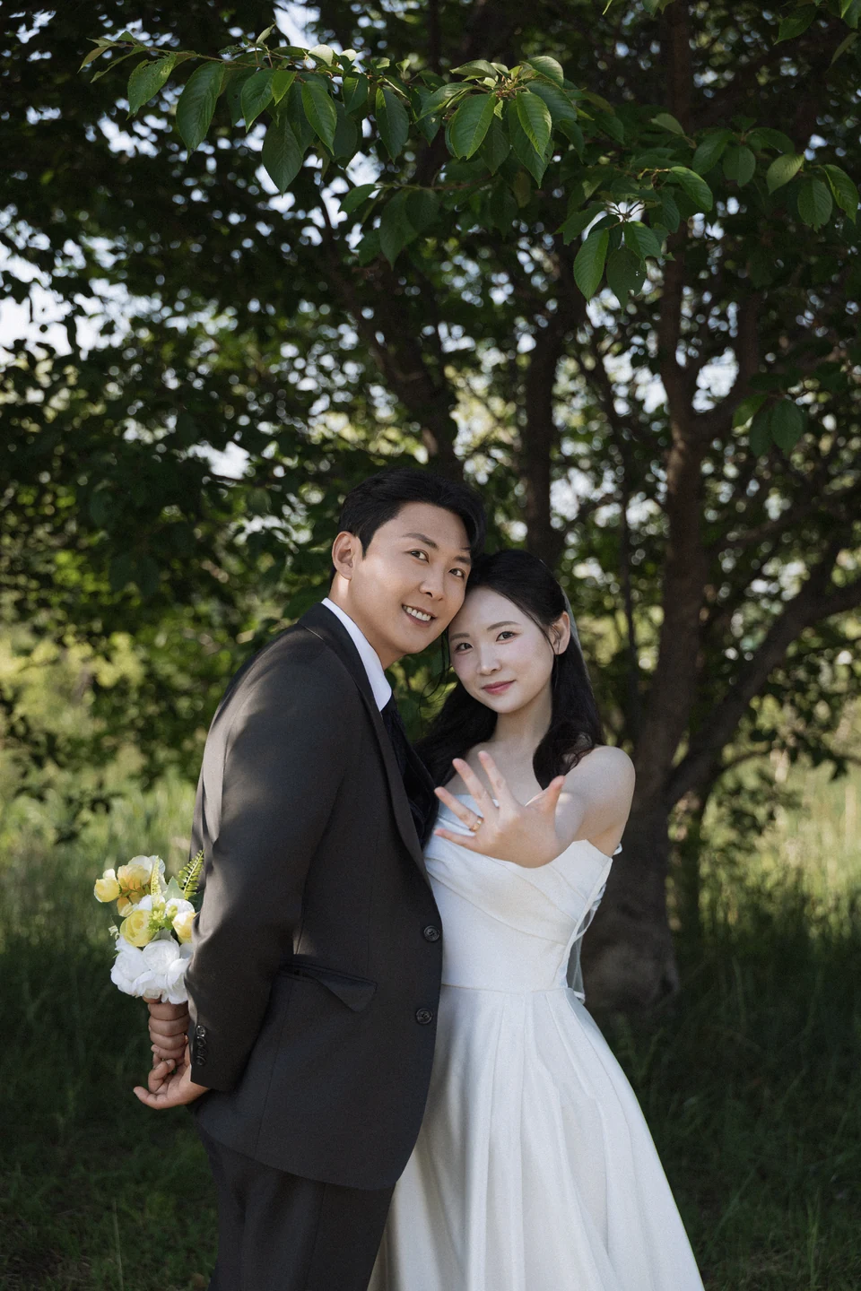 초록 나무 사이에서 함께 선 조황덕과 홍은주의 웨딩 사진